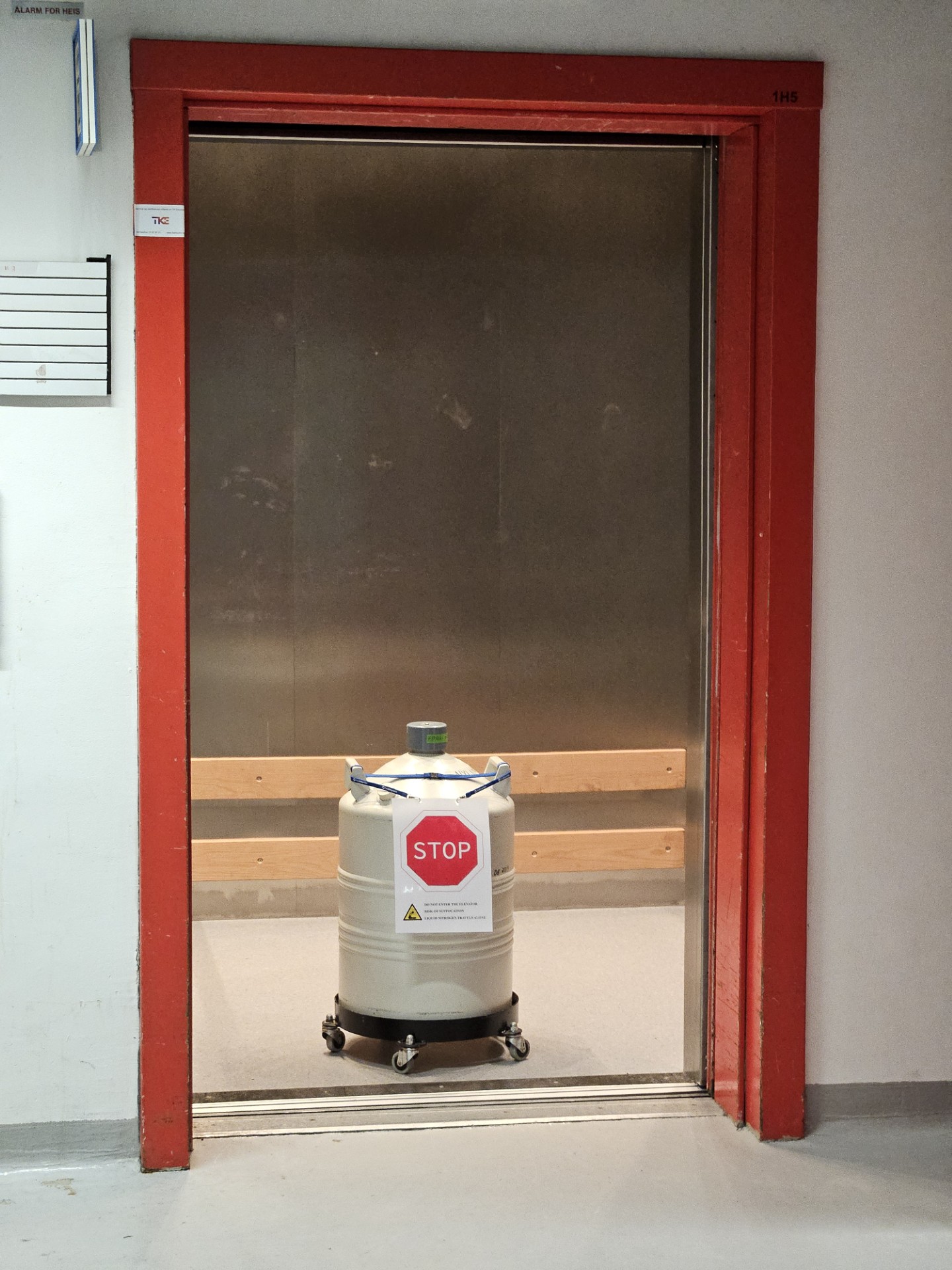 Photo of a liquid nitrogen container standing in an elevator and equipped with a STOP sign